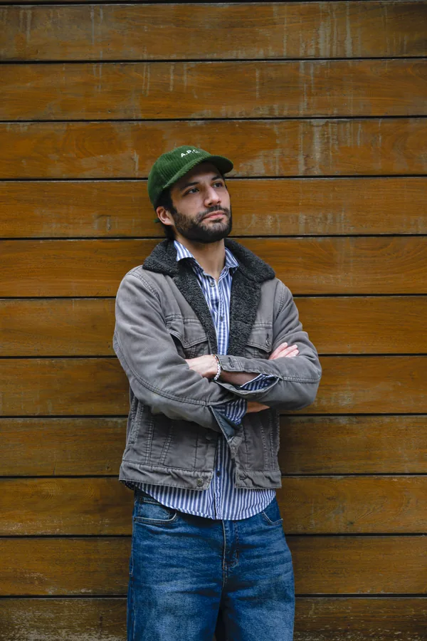 Portrait against a wood wall, arms folded