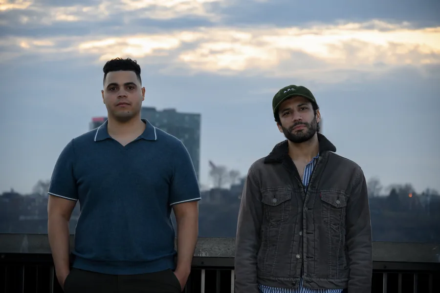 German & Victor On the waterfront at dusk, the skyline behind