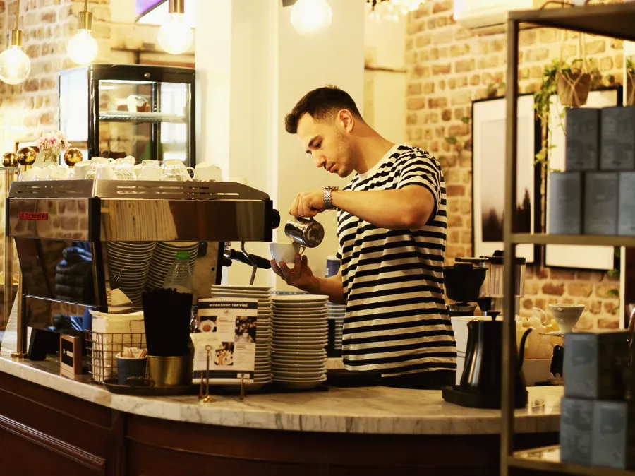 A barista pouring at a neighbourhood coffee bar