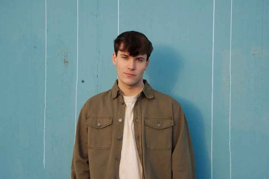 Against a pale blue clapboard wall