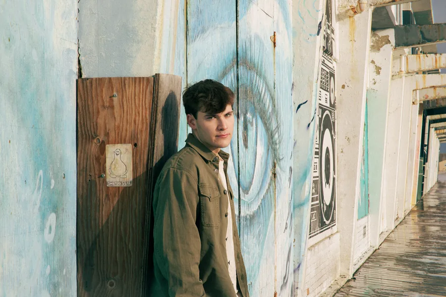 Leaning on a painted wall beside a doorway